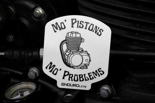 Sticker with engine graphic and text 'Mo' Pistons Mo' Problems' on a mechanical background